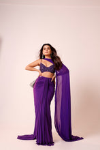 Load image into Gallery viewer, A woman modeling a purple saree with a matching embellished crop top, standing against a plain light beige studio background.